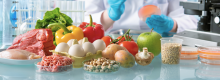 Fresh fruit and meat in the foreground on a table in a chemistry lab