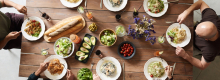 Overhead shot of people at a table eating from a variety of dishes