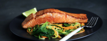 Fish with vegetables and a lemon on a plate.