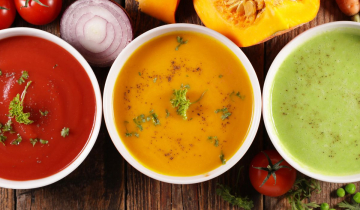 3 Different bowls of soup on a wooden table